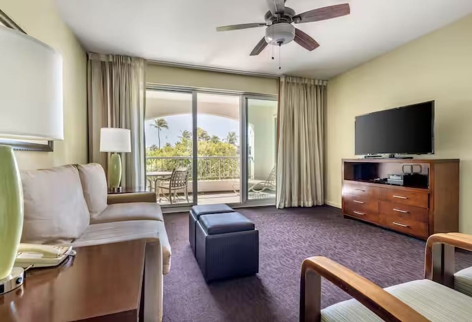 Lounge with a movie night setup and sunny balcony views.