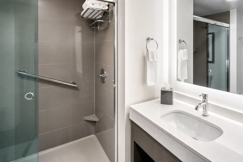 Refresh in a spotless, modern bath with bright vanity lighting.