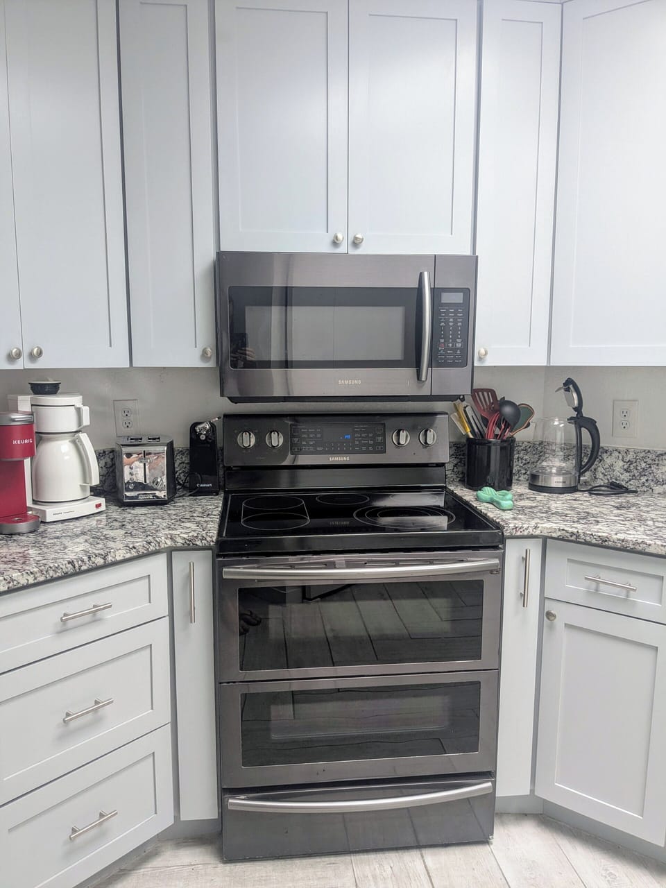 Range has two tiered ovens, glass stovetop, and built in microwave.