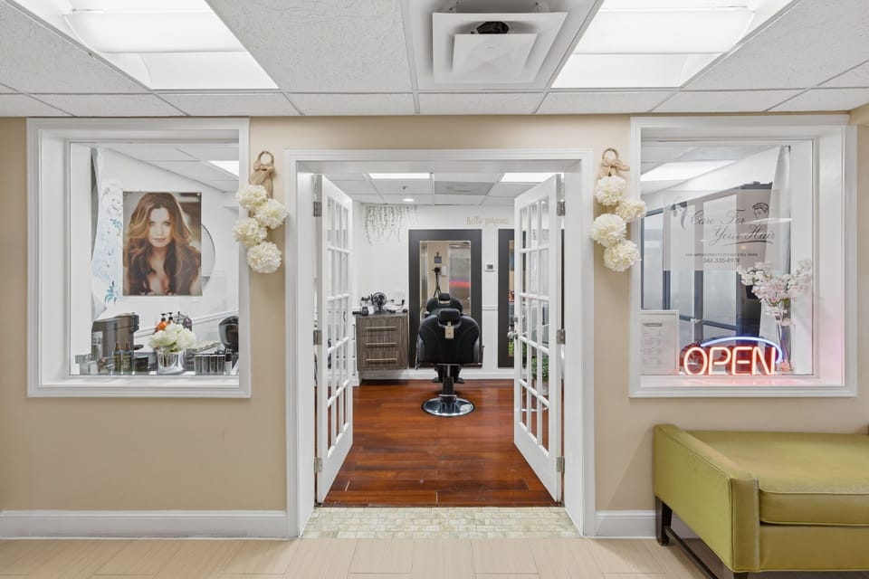Open salon entrance with hair styling station and floral decorations
