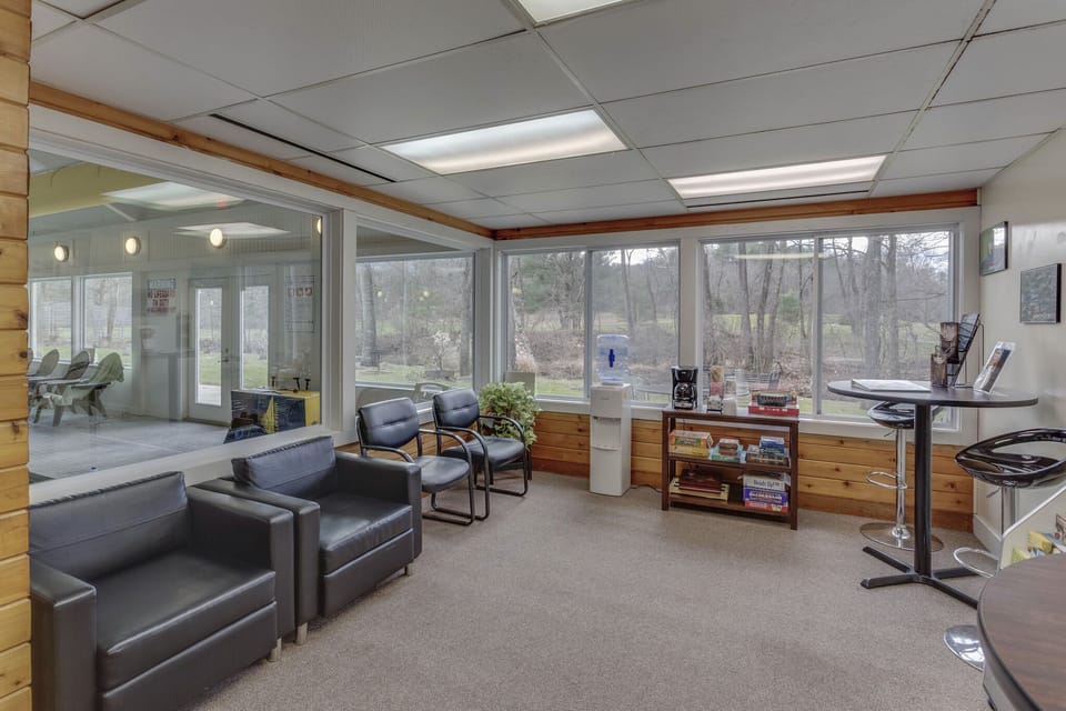 A comfortable lounge area with large windows invites relaxation and socializing, perfect for enjoying the serene surroundings.
