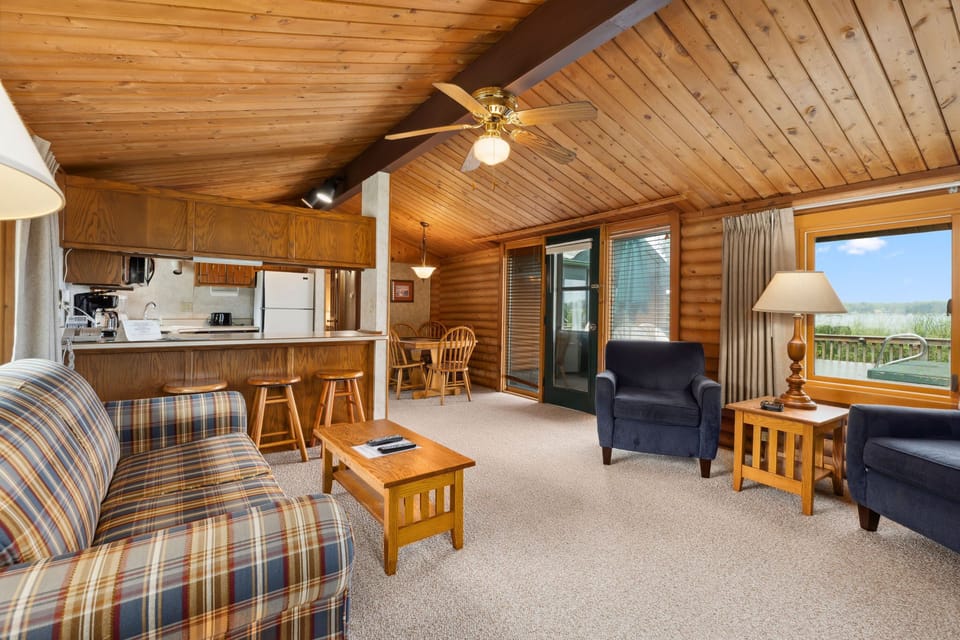 Open living area with rustic décor, comfy seating, and easy access to the kitchen.