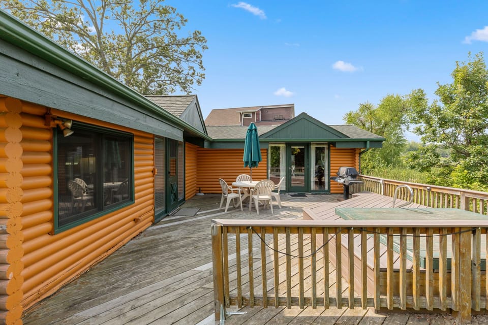 Spacious wooden deck with outdoor seating and umbrella, perfect for relaxing in the fresh air.