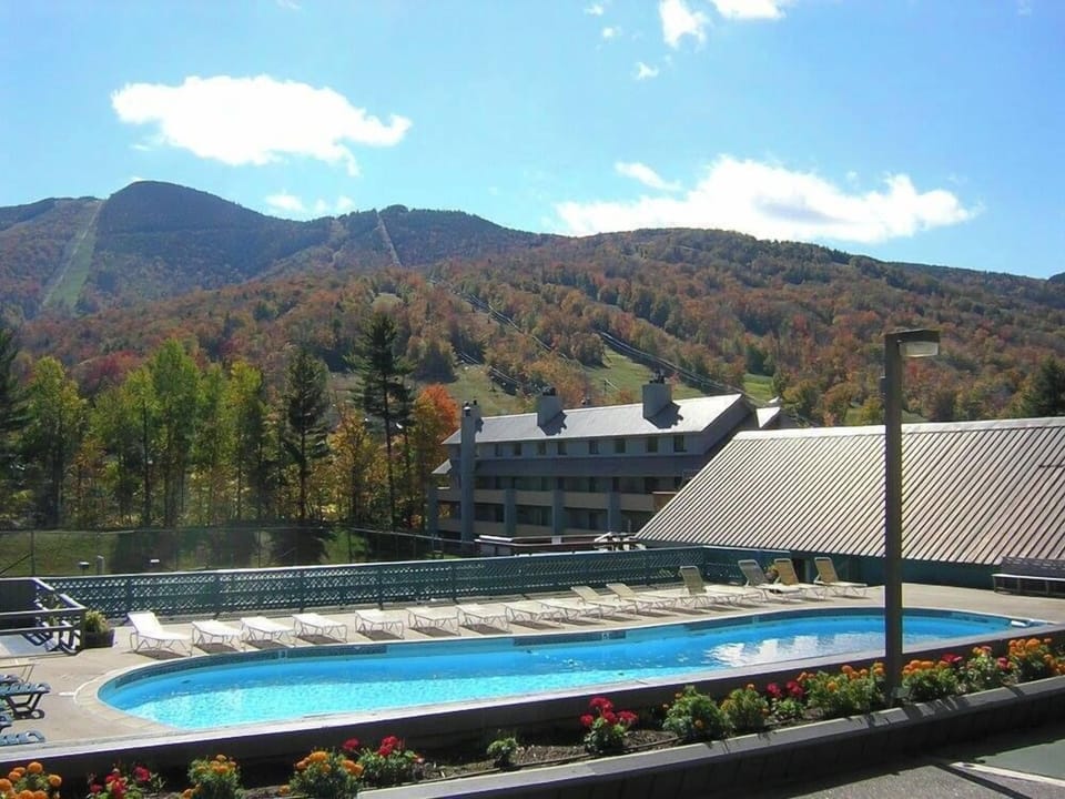 Enjoy breathtaking mountain views from the outdoor pool area, designed for family fun at the Village of Loon Mountain Resort.