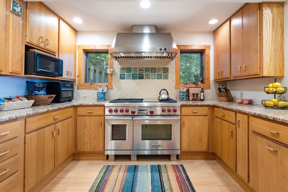 Cook with ease in a fully stocked kitchen featuring a professional-grade Wolf range, quality cookware, and all the essentials to inspire your inner chef—perfect for everything from quick breakfasts to memorable group dinners. 