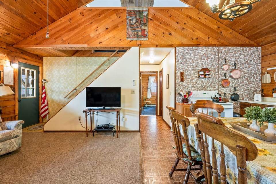 Charming living space with vaulted ceilings, recliners, and a flatscreen TV—ideal for movie nights at the lake. 🎬🔥🪵