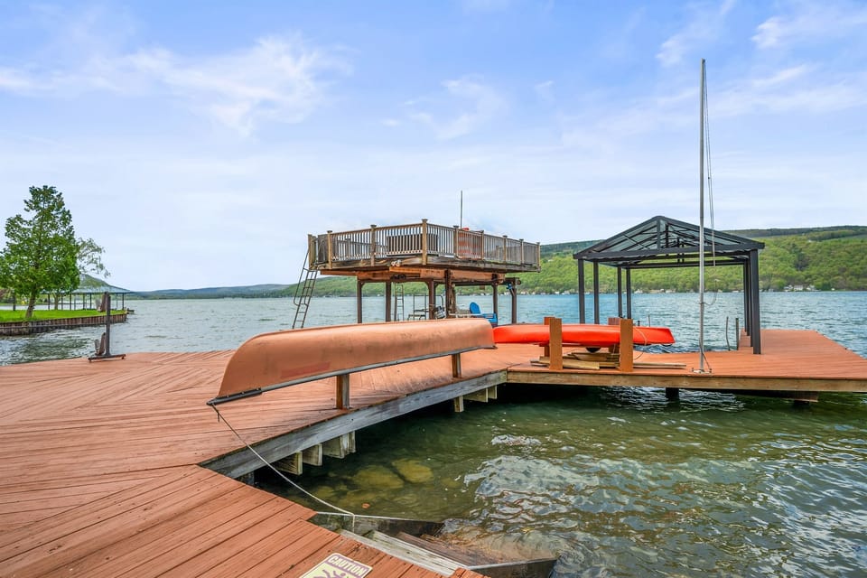 Expansive lakefront deck with seating, a canoe, and stunning water views—your private Finger Lakes retreat. 🚣‍♀️🌊☀️
