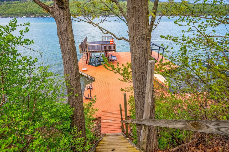 Expansive lakefront deck with seating, a canoe, and stunning water views—your private Finger Lakes retreat. 🚣‍♀️🌊☀️