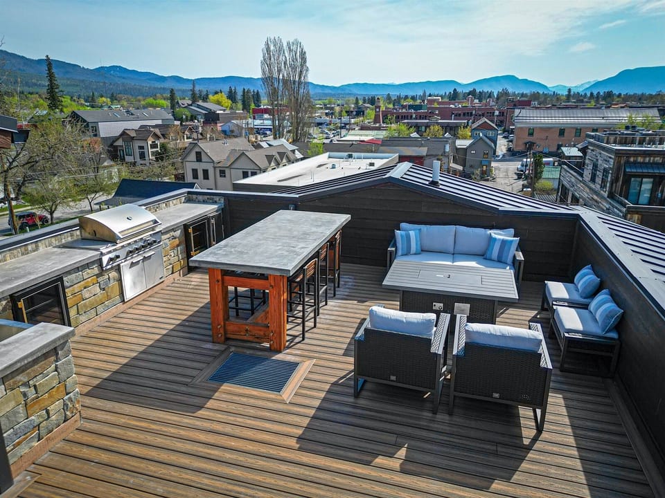 The shared rooftop patio offers guests access to an outdoor kitchen & grill, dining area & patio seating with gas fire pit | Exterior
