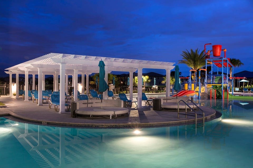 Enjoy the resort pool and splash area, beautifully lit after sunset