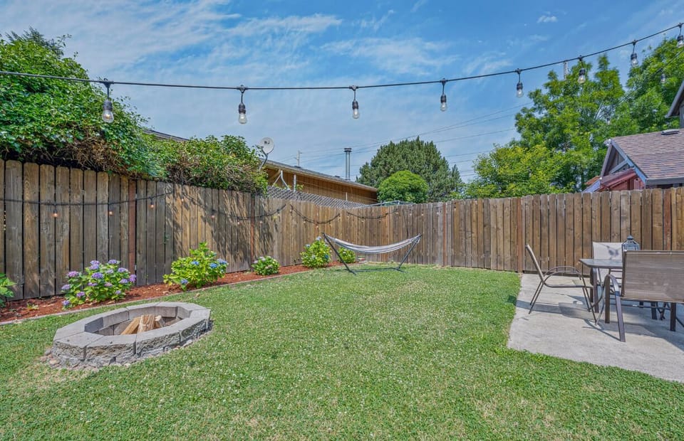 Backyard with BBQ grill, patio table set, and firepit. No hammock.