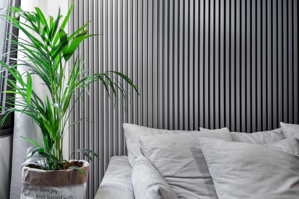 Textured accent wall and greenery create a peaceful corner perfect for unwinding anytime.