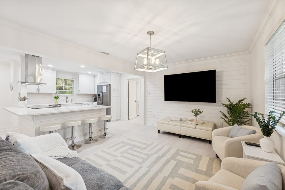 Unwind in the spacious, open-concept living room featuring comfortable seating, a Smart TV, and abundant natural light.
