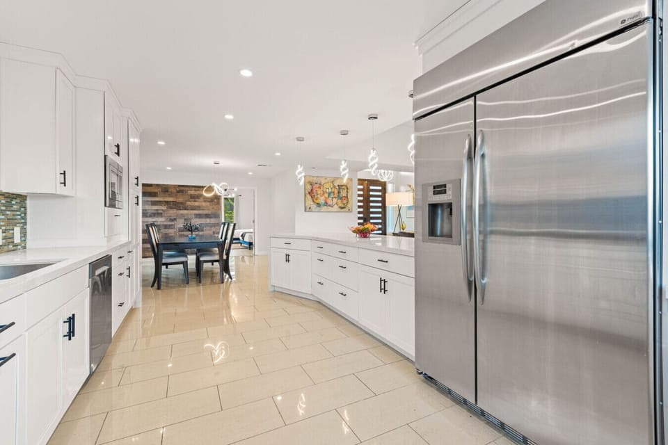 Gourmet kitchen with oversized fridge and open flow to dining space.