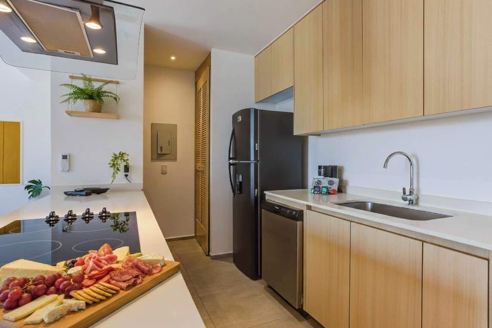 Sleek kitchen w/ wood cabinetry, modern appliances & bright counter space