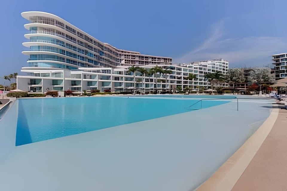 Shared pool w/ sweeping architecture creating a striking waterfront scene