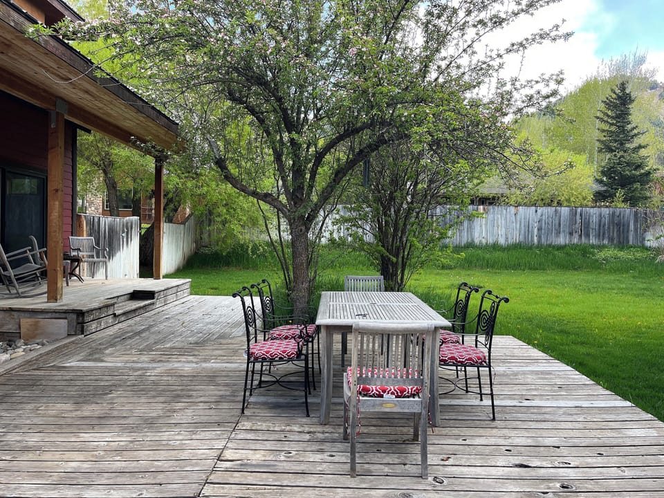 Outdoor dining with a view of Snowking surrounded by a larged fenced in yard.