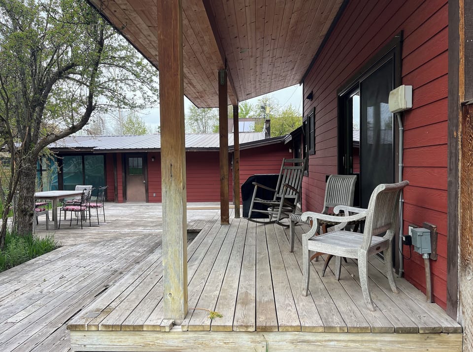 The backyard features a covered deck and BBQ next to the kitchen.