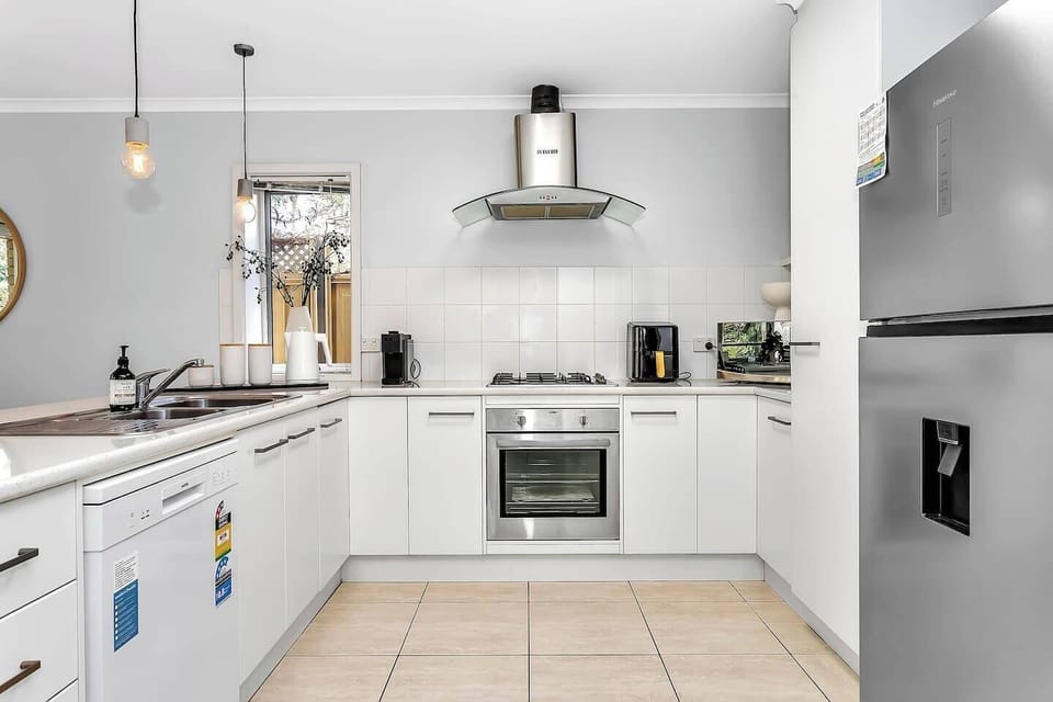 Modern and functional kitchen with gas cooktop, espresso machine, and island seating.