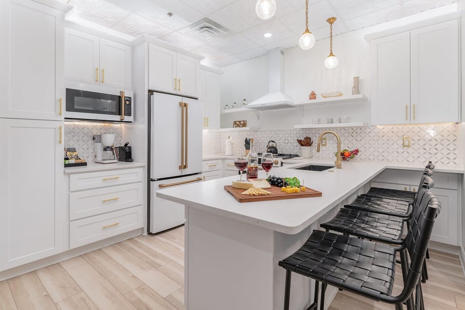 Fully Equipped Kitchen featuring stainless steel appliances, open counter space, and bar seating for 4 guests.