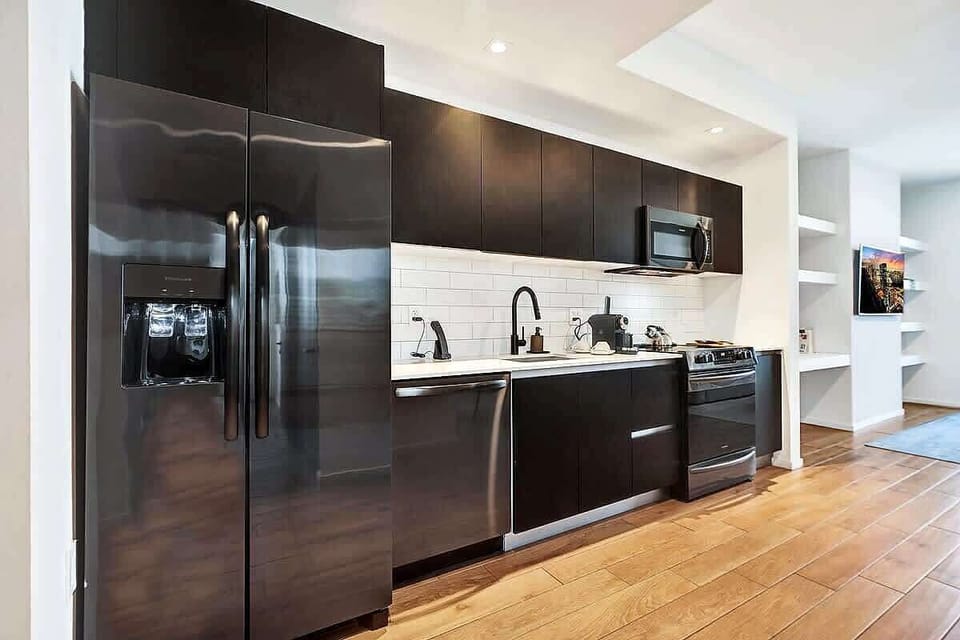 Sleek dark kitchen with subway tile backsplash