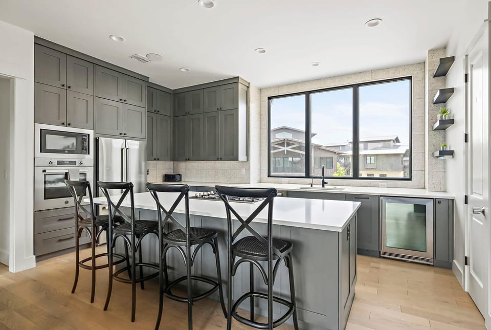 The sleek chef’s kitchen is a culinary dream, featuring gleaming stainless steel appliances, a five-burner gas range, a dedicated beverage fridge, and all the tools needed to inspire your inner foodie.