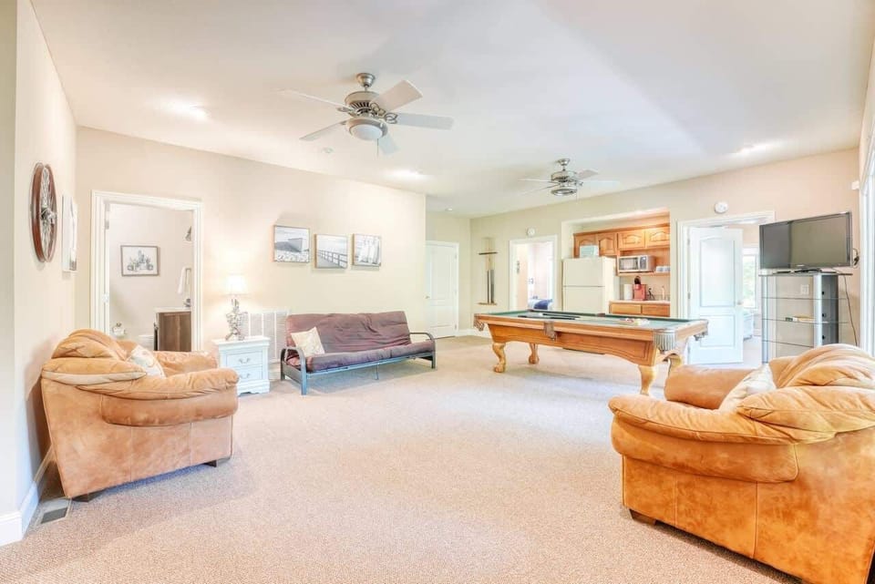 Lower-level lounge with pool table, sectional sofa, and TV—gather for games and movies.