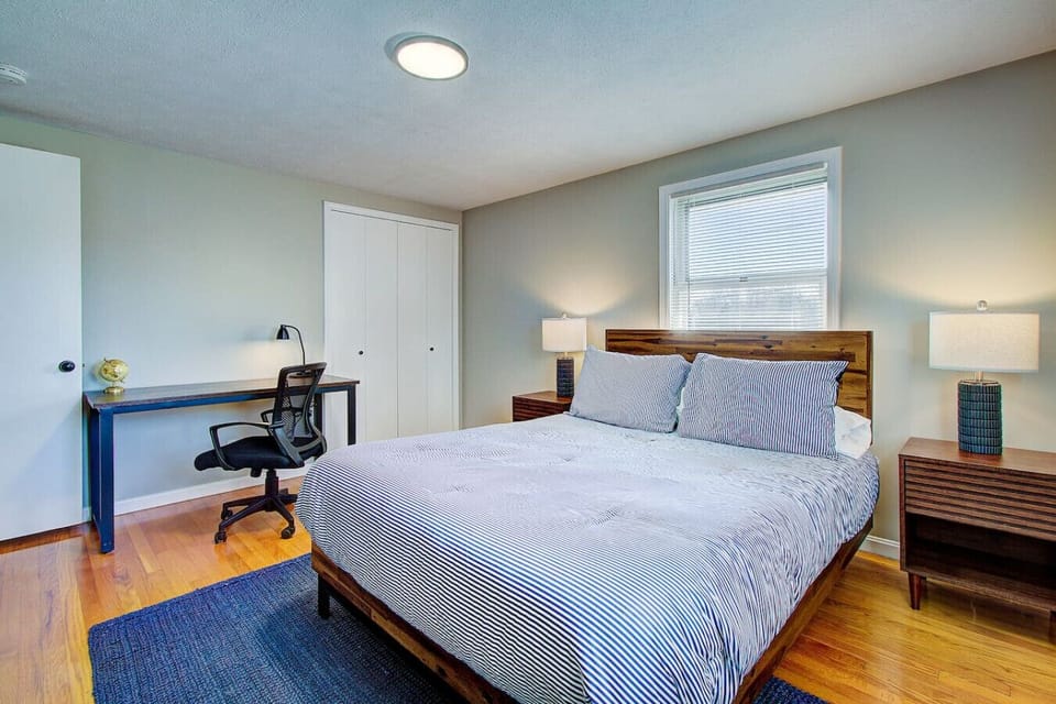 Queen bedroom with a Smart TV, dedicated workspace, and room-darkening blinds.