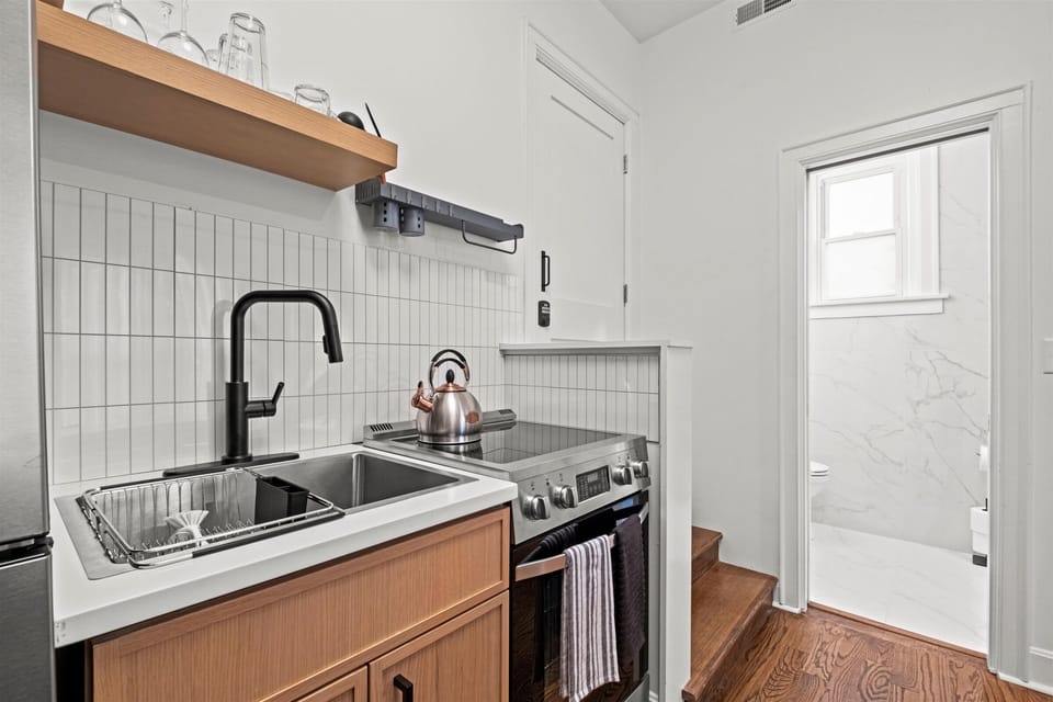 Fully equipped kitchen featuring a gas range, modern sink, open shelving, and everything needed to cook comfortably during your stay.