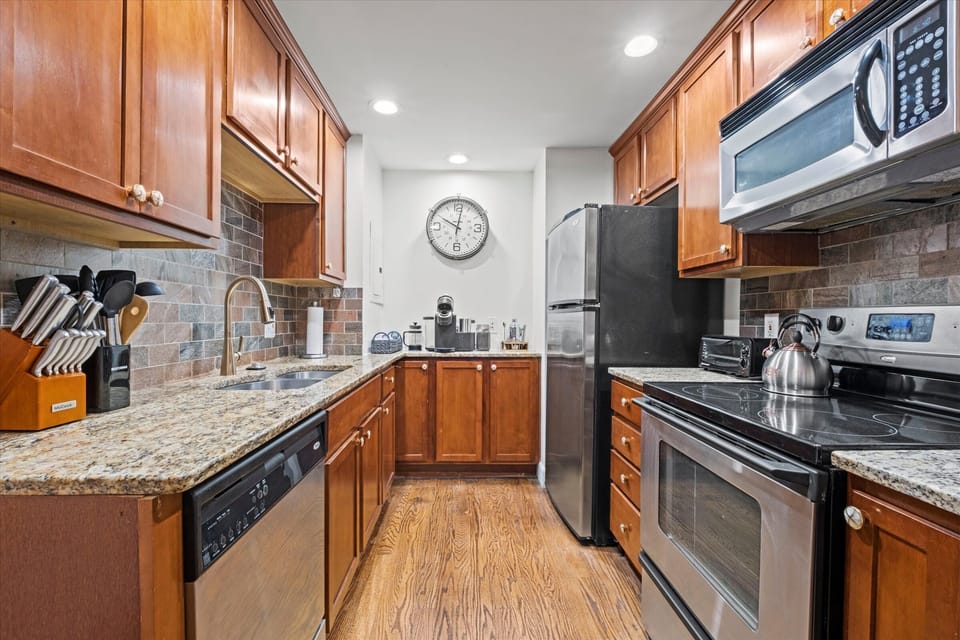 Fully equipped kitchen with granite countertops, stainless steel appliances, and generous cabinet space—perfect for longer stays or home-cooked meals.