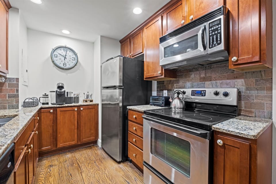 Compact yet fully equipped kitchen with stainless steel appliances, granite countertops, and plenty of storage—perfect for studio living steps from the Plaza.