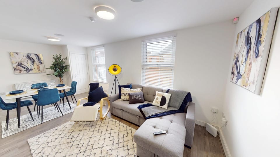 Unwind in the bright living space, featuring a comfortable sofa bed and large Smart TV—perfect for relaxed evenings, movie nights, or accommodating an extra guest with ease