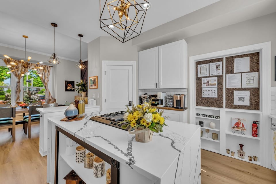 Bright kitchen with coffee bar, island cooktop & peek into dining space
