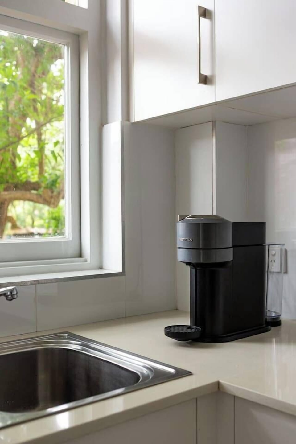 Wake up to the aroma of fresh espresso from your Nespresso machine, perfectly positioned beside a garden-facing window for a serene start to the day.