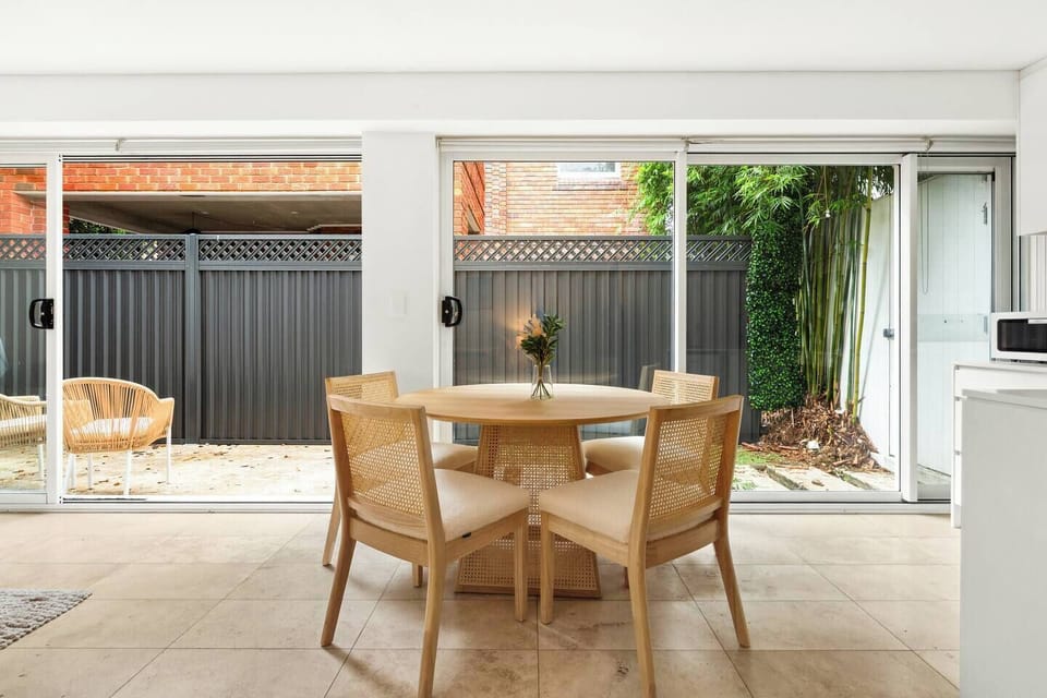 Enjoy meals or a morning coffee at the timber dining table, surrounded by natural light pouring in through full-height glass doors.