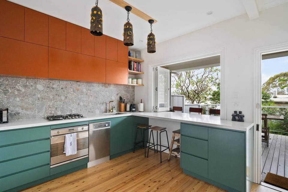 Cook with ease in the fully renovated kitchen, complete with forest green cabinetry and stone finishes.