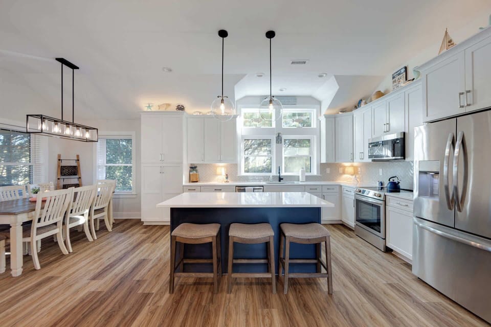 Updated kitchen with quartz countertops, stainless steel appliances, and expansive island with bar seating for 3