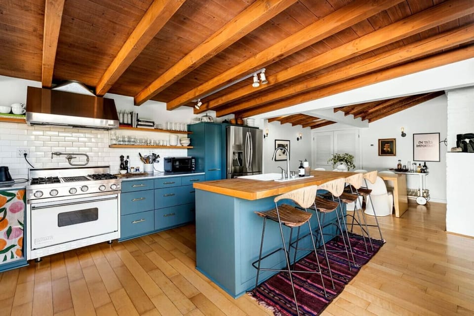 Stylish kitchen featuring a sleek center island, elegant wooden ceiling, and additional countertop seating—perfect for dining and entertaining.