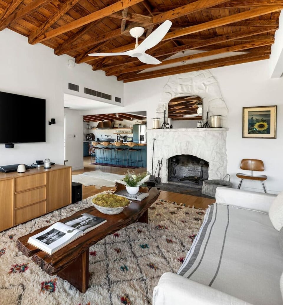 Cozy living room featuring a wooden design with elegant white-painted walls, creating a warm and inviting ambiance.