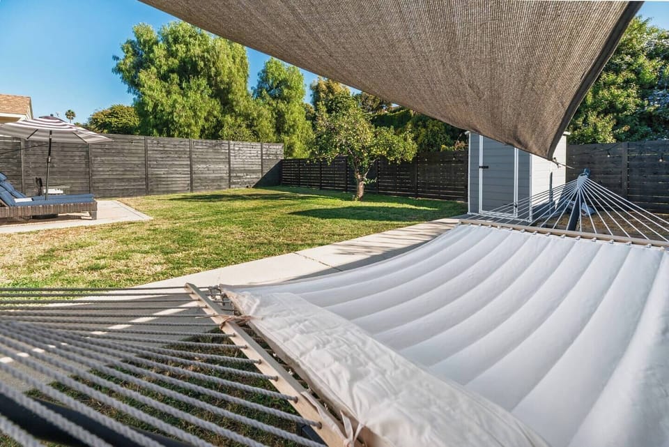 Relax in our sunny backyard oasis featuring a cozy hammock