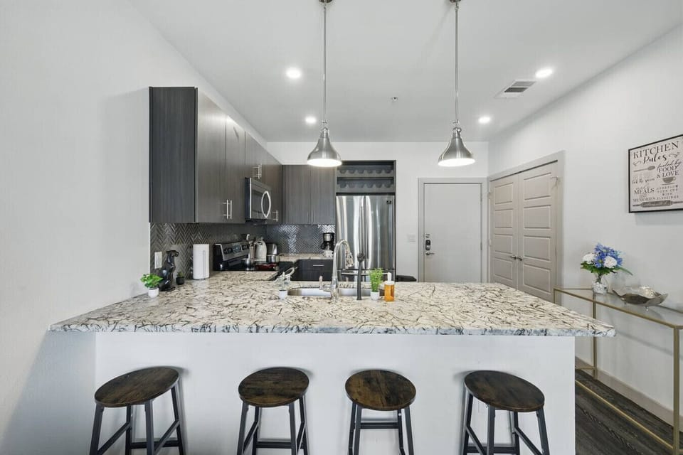 - Open kitchen layout with granite breakfast bar seating - Stainless appliances, pendant lighting and ample storage - Modern city apartment ideal for business or leisure stay