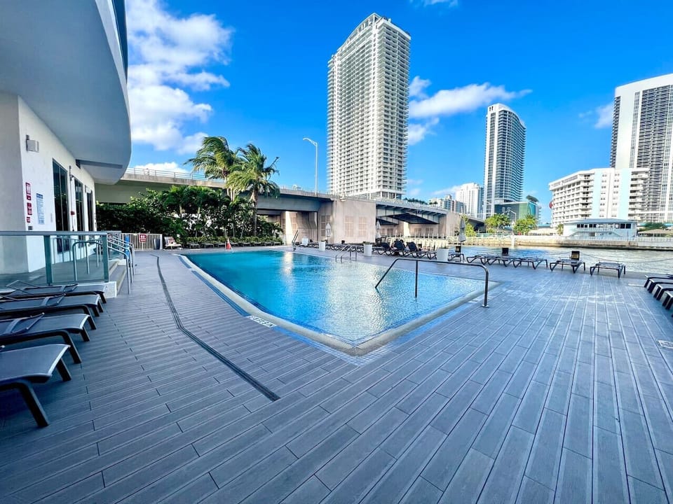 Outdoor pool surrounded by high-rises and cityscape views.