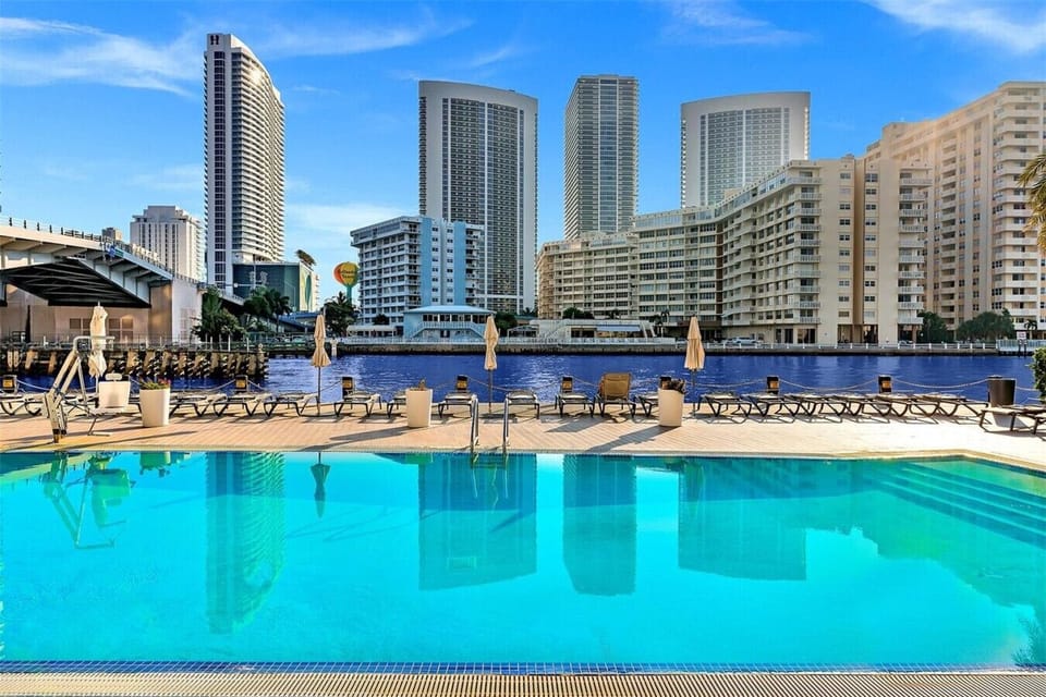 Outdoor pool surrounded by high-rises and cityscape views.