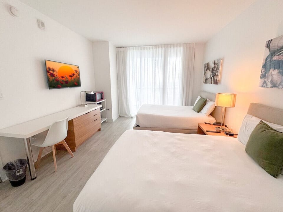 Spacious bedroom with balcony access and Smart TV.