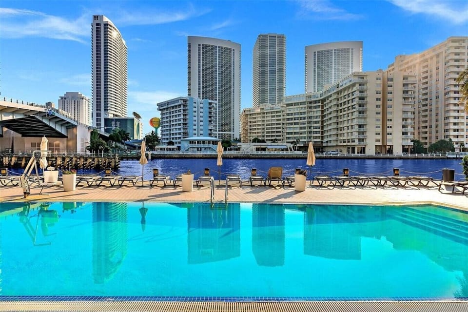 Outdoor pool surrounded by high-rises and cityscape views.