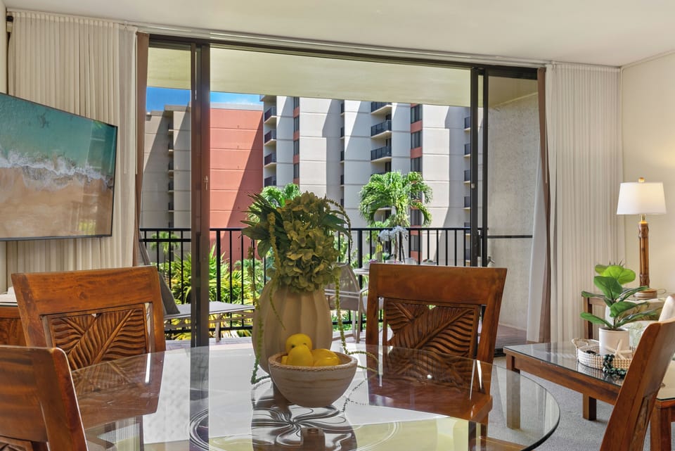 Indoor dining area with tropical décor and large windows overlooking lush greenery for a relaxing mealtime ambiance.