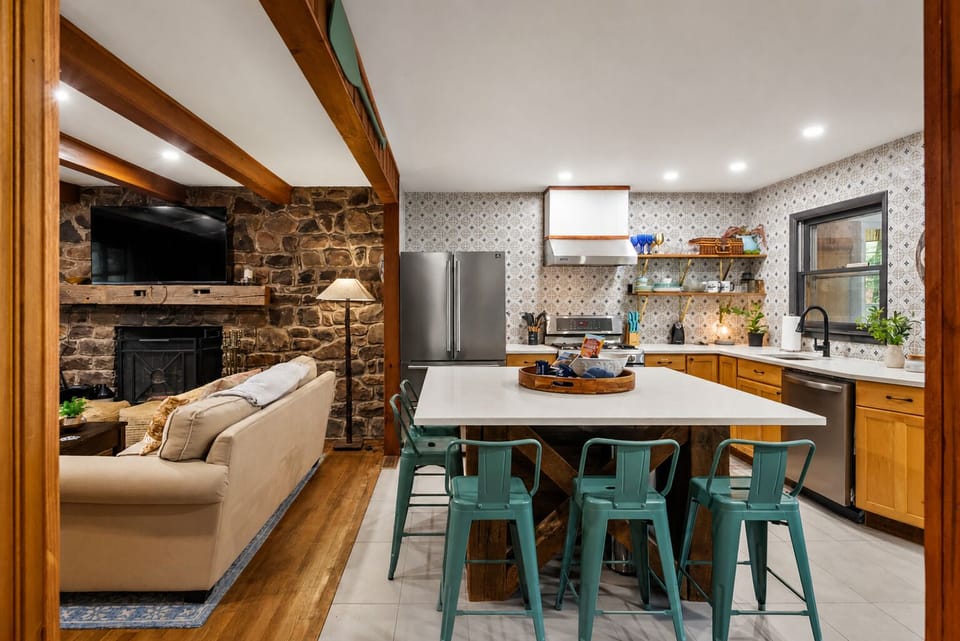 Cozy up in this warm and inviting living space with rustic wood beams, plush seating, and the perfect setup for movie nights after a day outdoors.