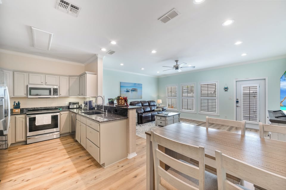 Your open-concept retreat seamlessly blends kitchen, dining, and living spaces with granite counters, stainless appliances, and coastal charm for effortless entertaining.
