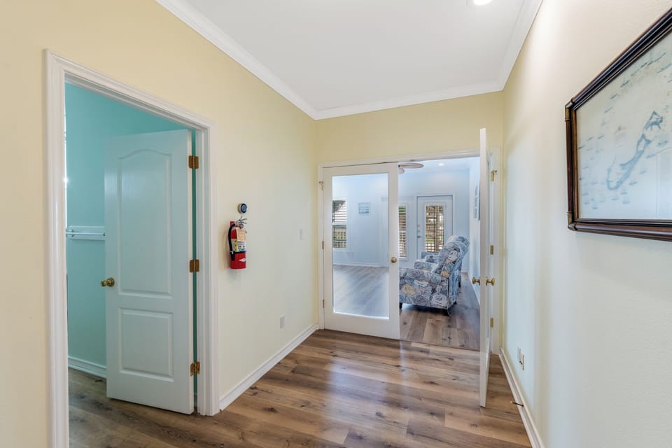 Step into your welcoming hallway where warm wood floors guide you to comfortable living spaces throughout your coastal retreat.