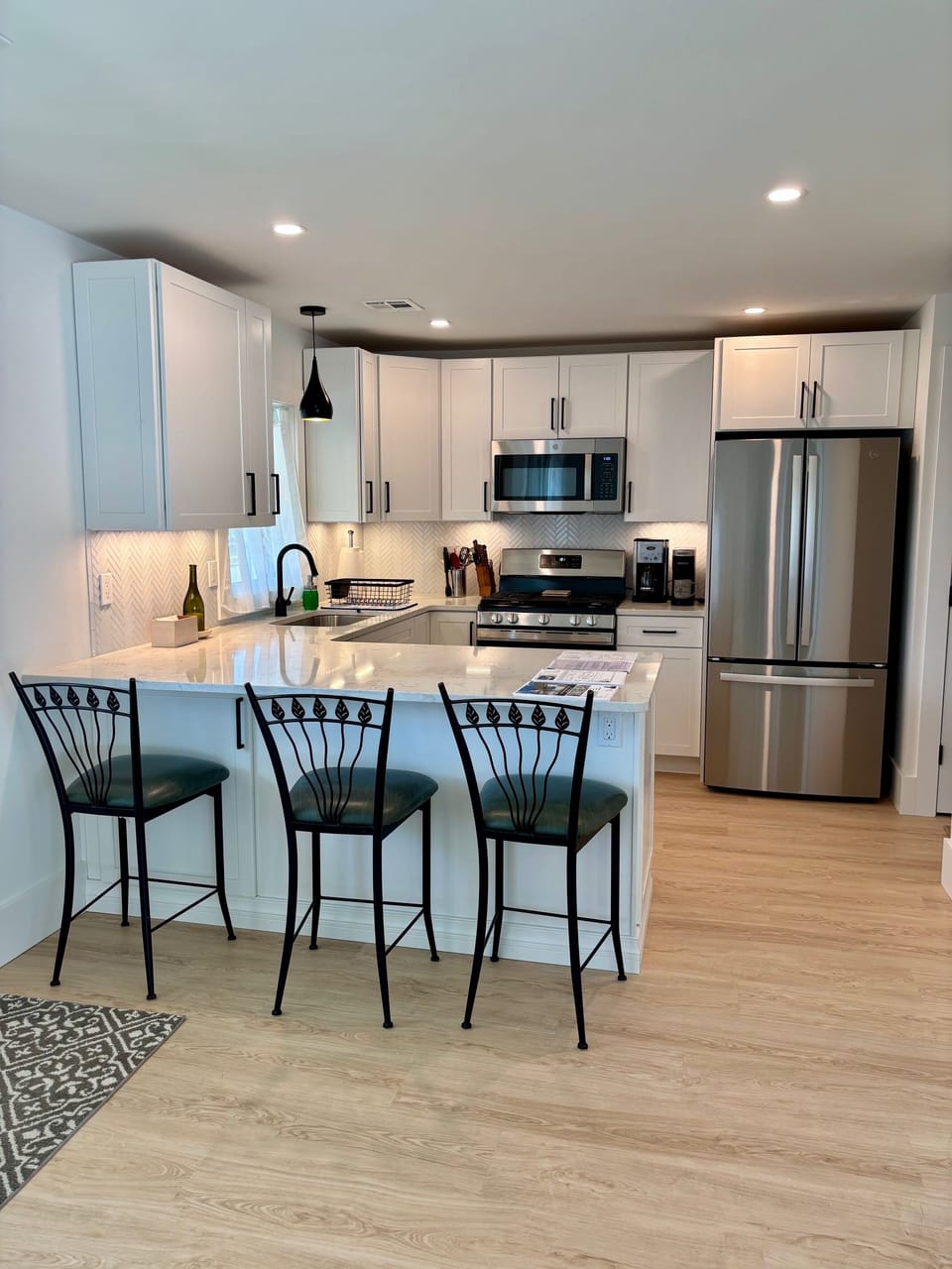 Kitchen with counter seating. Ice maker, dish washer, coffee maker, water filter